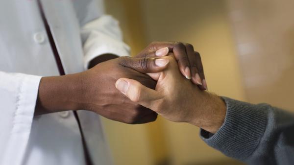 Doctor holding patient hands in support